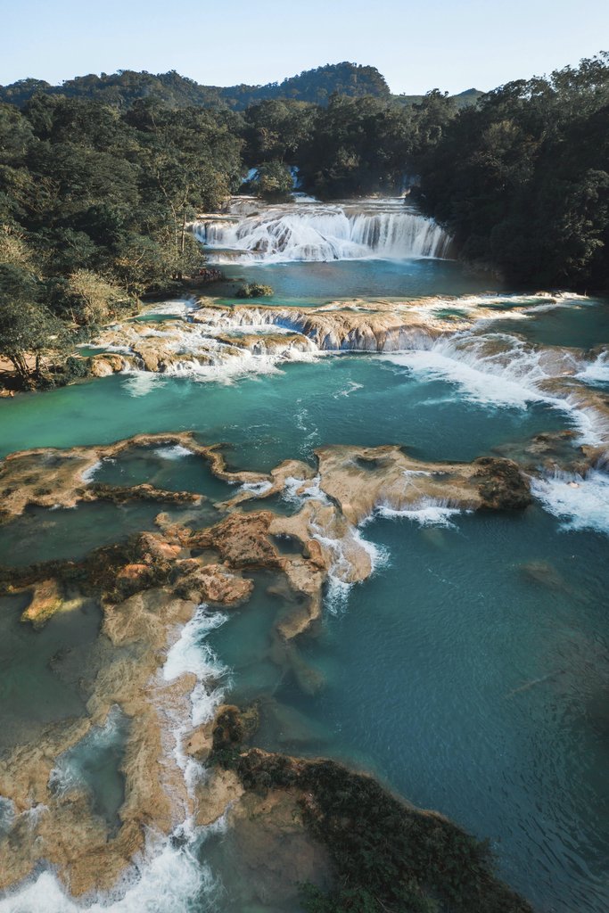 Mikhail Nilov - A breathtaking aerial view of stunning turquoise waterfalls amidst lush greenery.