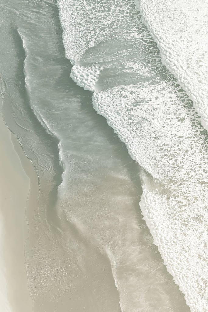 This artwork shows soft ocean waves washing onto smooth sand from above.