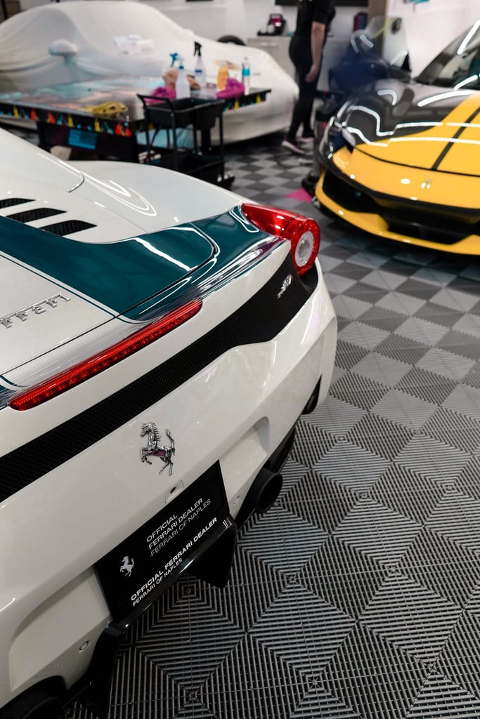 Ferrari Showroom Elegance showcasing a white Ferrari sports car and a yellow Ferrari in a luxury garage setting. Car wall art.