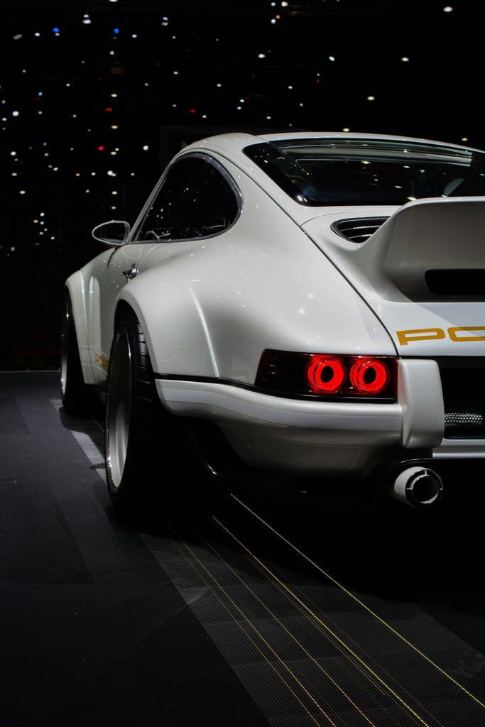 Porsche 911 Restomod in white with glowing tail lights, showcasing custom bodywork and aggressive stance - car wall art.