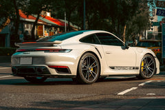 Porsche 911 Turbo S on a Taipei Street, pristine white sports car parked curbside in vibrant urban setting.