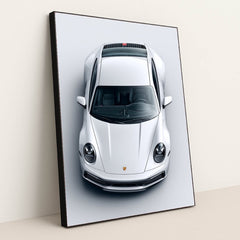 This photo shows a top-down view of a white Porsche 911 against a light gray background, in a black frame.