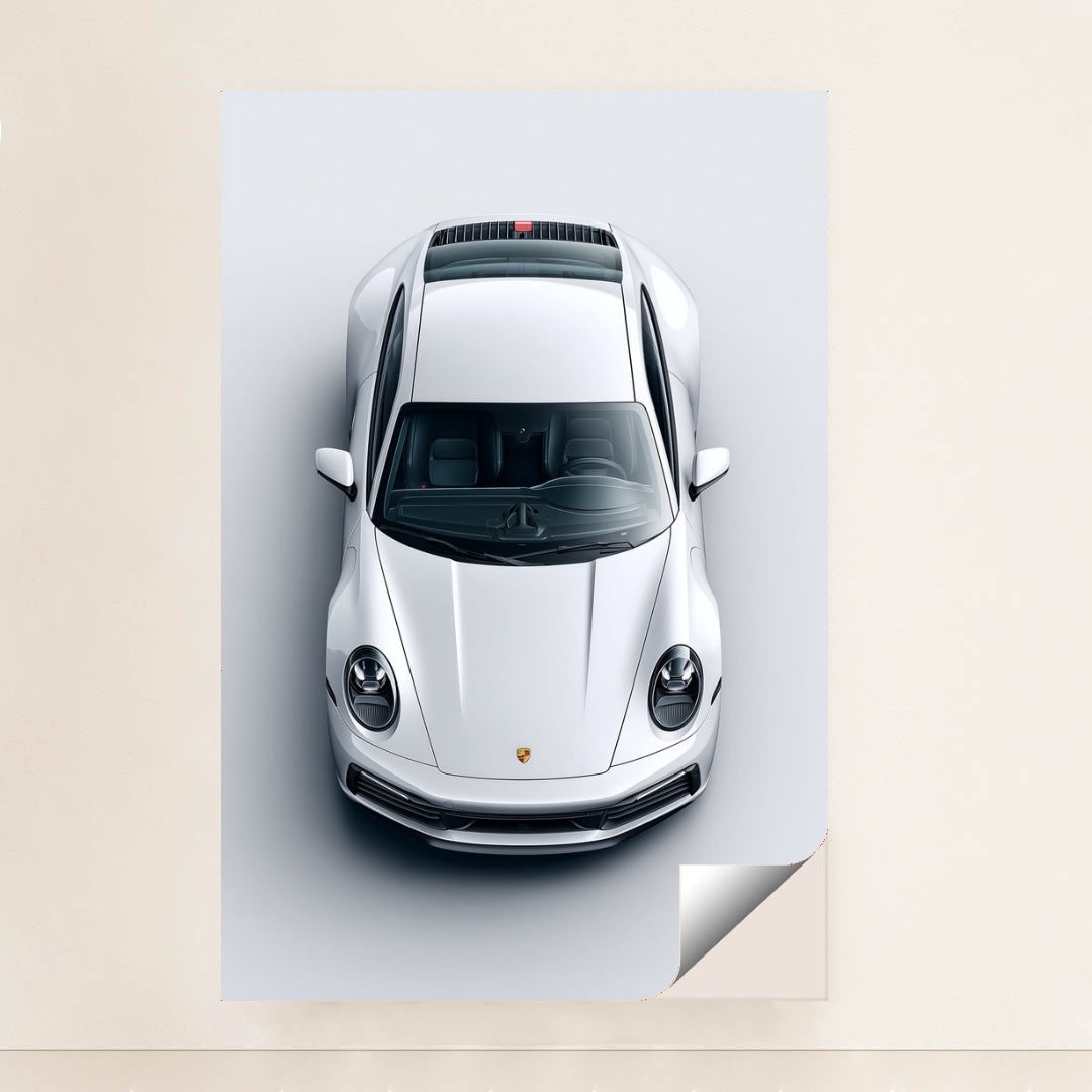 This photo shows a top-down view of a white Porsche 911 against a light gray background, unframed.