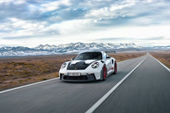 Porsche 911 GT3 RS on Desert Highway, white car with red wheels racing on a desert road with mountains in the background.