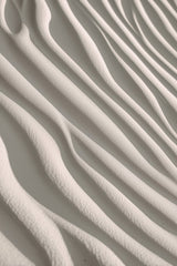 This artwork shows smooth, wavy lines of pale sand in soft sunlight.