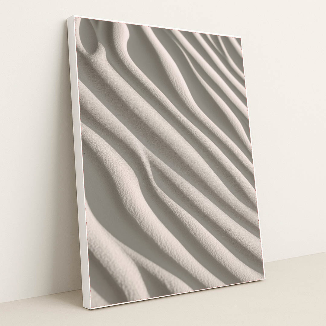 This artwork shows smooth, wavy lines of pale sand in soft sunlight, in a white frame.
