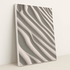 This artwork shows smooth, wavy lines of pale sand in soft sunlight, in a white frame.
