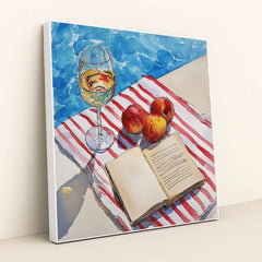 This artwork features a wine glass, peaches, and an open book on a striped towel beside a pool, in a white frame.