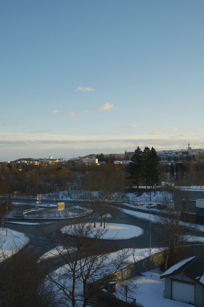Dua'a Al-Amad - Beautiful winter cityscape featuring a snowy road and distant buildings under a clear sky.