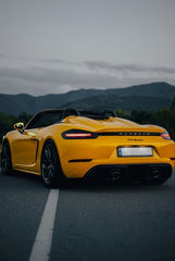 Racing Yellow Porsche 718 Spyder at Dusk on a winding road, showcasing car wall art and stunning alpine scenery.